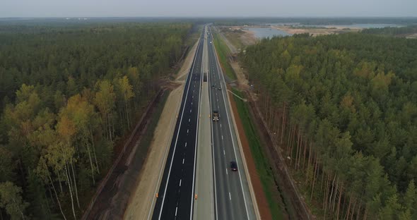 Aerial View of Cars Driving on Newly Built Highway Between Green Forest