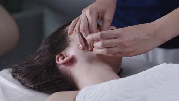 Woman Massagist Doing a Face Massage Using Her Fingers on Her Female Client