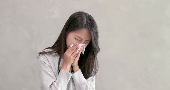Woman sneezing and feeling sick