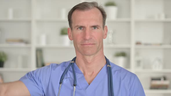 Portrait of Unhappy Middle Aged Doctor Showing Thumbs Down