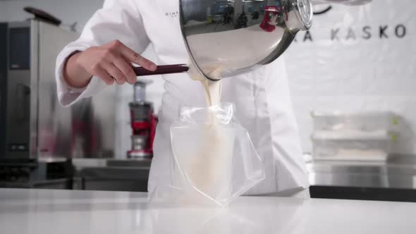 Pastry Chef Pours the Mousse Into a Pastry Bag