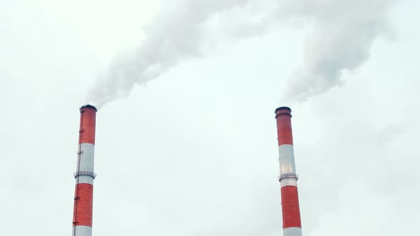 Boiler House Chimney. Steam Against the Cloudy Snowy Sky. Industrial Zone of the City