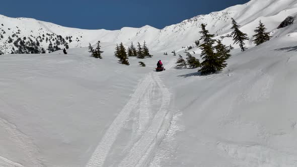 Snowmobile high in the mountains aerial view 4 K