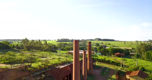 Chimneys of a industrial ceramic at sunny day. Aerial view tilt