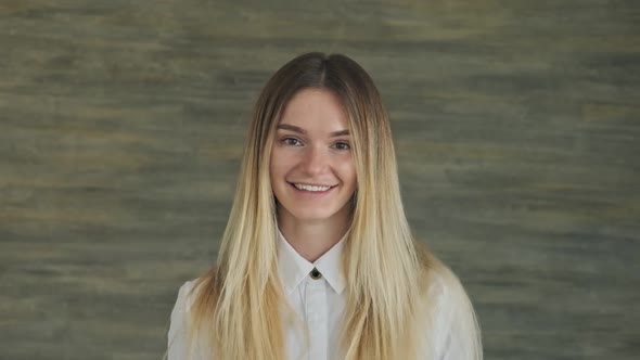 Portrait of Beautiful Young Blonde Woman in White Shirt in Office