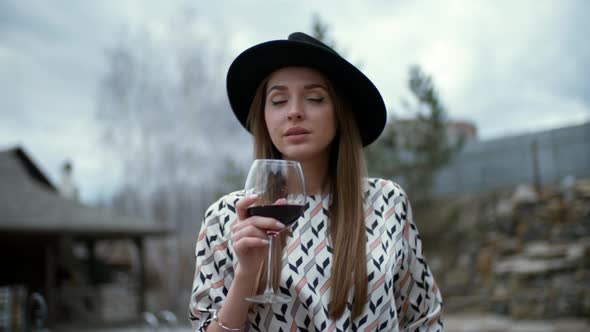 Sassy Brunette Sipping Red Wine Outdoors