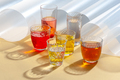 Colored drinks in glass cups on a yellow background with additio - PhotoDune Item for Sale