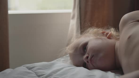 Baby girl lying in bed in the morning