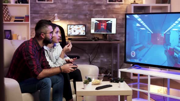 Man Sitting on Couch Playing Video Games on Television