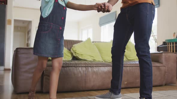 African american father and daughter dancing at home