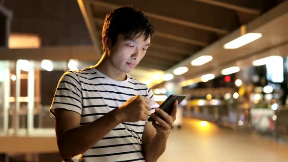 Young man use of mobile phone in the city 