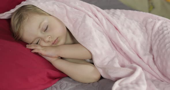 Cute Baby Sleeping on the Bed at Home. Little Girl Sleeping in Morning Light