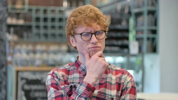 Curious Young Redhead Man Thinking About Something 