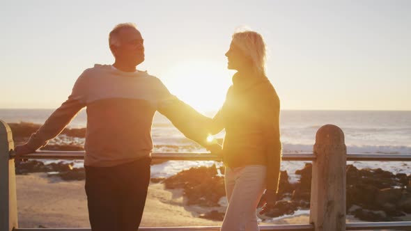 Senior couple standing in front of beach