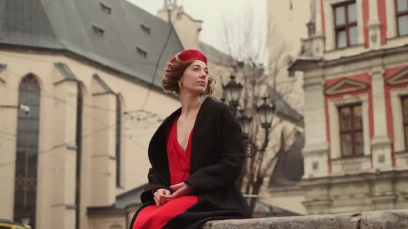 Young Woman Sitting On The Street Of The Ancient City And Looking Somewhere.