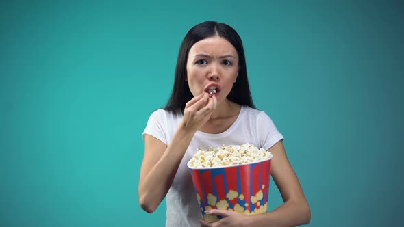 Focused on Movie Woman Devouring Popcorn From Big Paper Cup, Unhealthy Eating