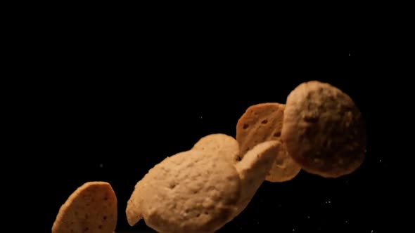 Slow motion cookies flying on black background.