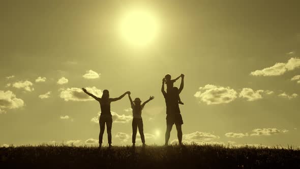 Happy Family Walking in Field on Sunny Day. Concept of Friendly Family.