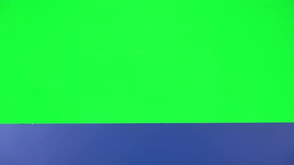 Girl Looking Out From Behind Blue Blank Placard on Green Screen at Studio, The Board Is Horizontal