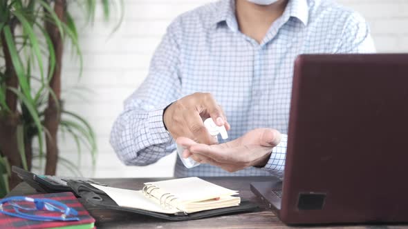 Businessman Applying Sanitizer Liquid Before Using Laptop