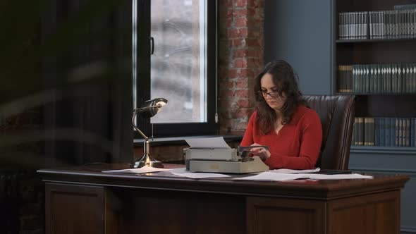 Woman Working at Her Desk with Vintage Typewriter