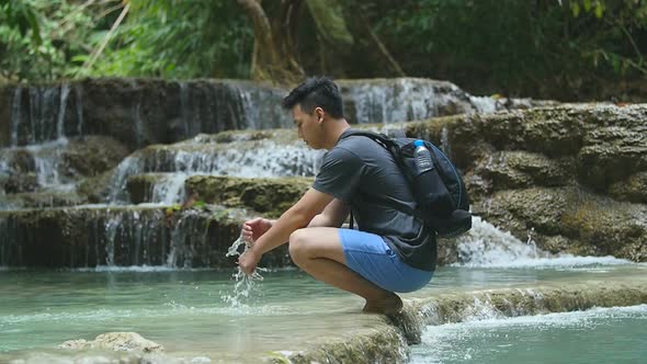 Man Playing Water at Waterfall