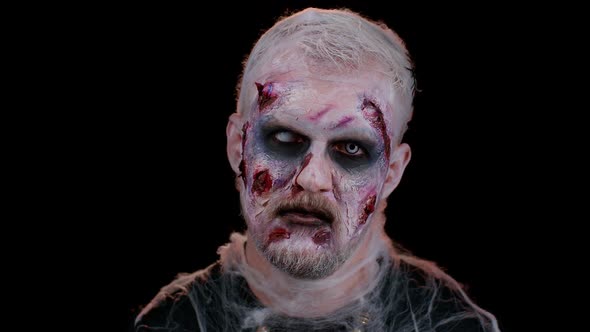 Frightening Scary Man with Halloween Zombie Bloody Wounded Makeup Trying to Scare Face Expressions