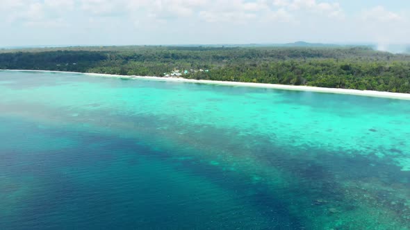 Aerial: flying over tropical beach coral reef turquoise water green forest uncon