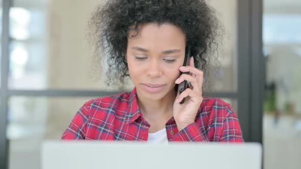 Close Up of African Woman with Laptop Talking on Phone