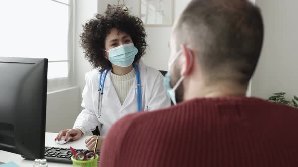 Doctor and Patient in Face Mask Talking in a Medical Consultation in a Clinic