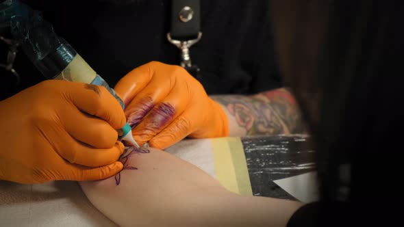 Tattoo Artist Draws a Picture on the Hand of a Young Woman, the Process of Creating a Tattoowith