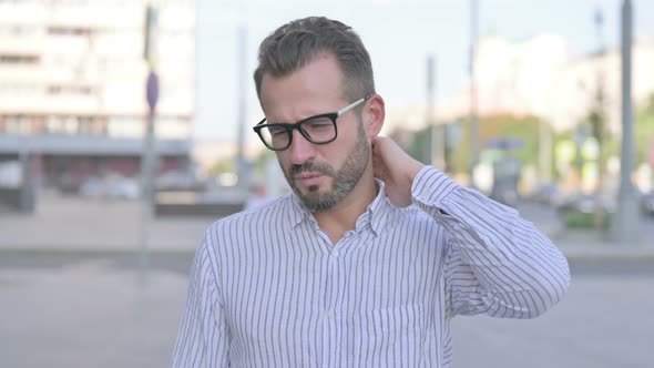 Portrait of Tired Young Adult Man with Neck Pain Outdoor