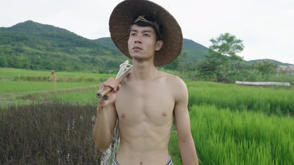 Asian Farmer Walking In Rice Field