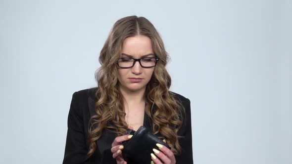 Businesswoman Holding Looking Into Empty Wallet on Gray Background in Studio, Slow Motion