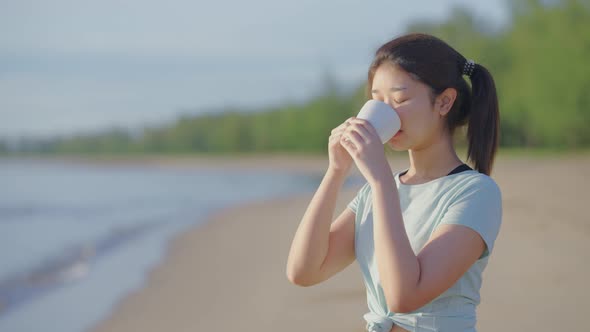 Asian cute girl She was drinking milk in the morning at the beach.