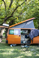 Camper in campsite. Outdoor equipment and travel van on green me - PhotoDune Item for Sale