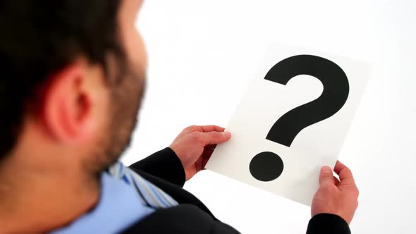 Businessman holding paper with question mark sign