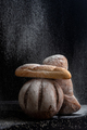Fresh bread under a pouring flour on a black background. - PhotoDune Item for Sale