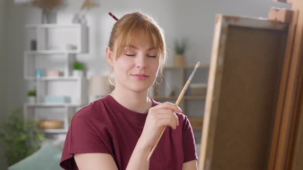 Portrait of a Young Beautiful Woman at Home Behind Easel