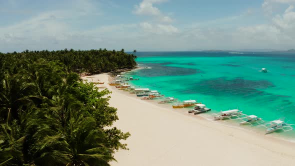 Tropical Daco Island with a Sandy Beach and Tourists