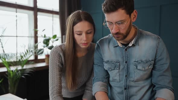 Young Woman and Man As an Architects Working with Blueprints, Laptop and House Models in the Office.