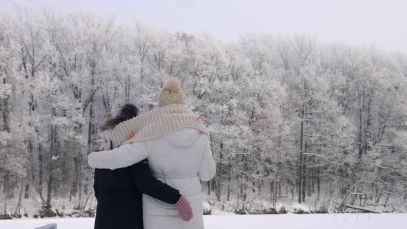 Woman with Her Daughter Looking at the Frost Trees