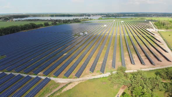 Aerial View on Solar Power Station in Green Field Near River at Sunny Day