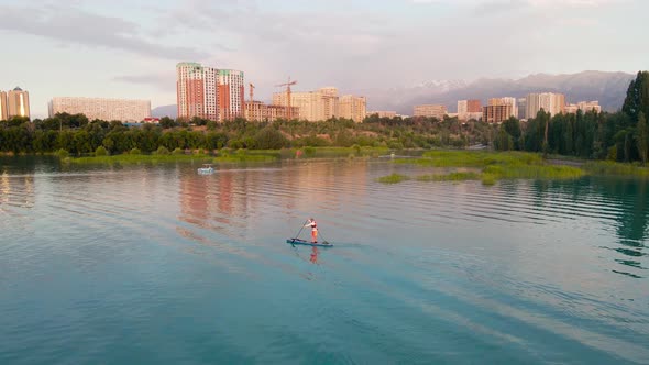 Man Ride on SUP Board in the Mountain Lake