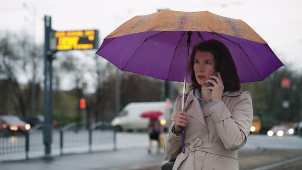 Woman Under Umbrella Talking on Phone