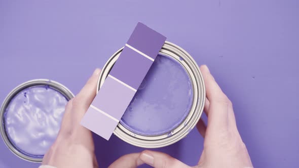 Close up of metal paint can with purple paint and paint swatch.