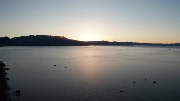 Reverse pullback aerial shot of Lake Tahoe at sunset in the summer. 4K