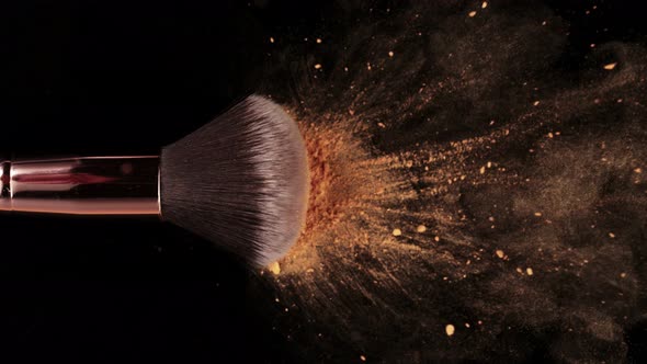 Super Slow Motion Shot of Makeup Brush and Brown Powder Falling on Black Table at 1000 Fps.