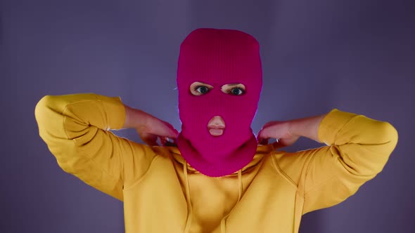 Young Woman in Pink Balaclava Puts on Hood