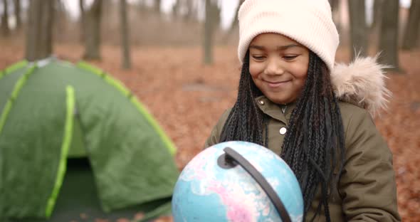 Mixed Race Girl Staying Near Camp in Autumn Forest